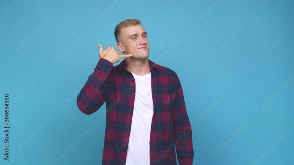 Young caucasian man showing a mobile phone call gesture with fingers Young caucasian man showing a mobile phone call gesture with fingers