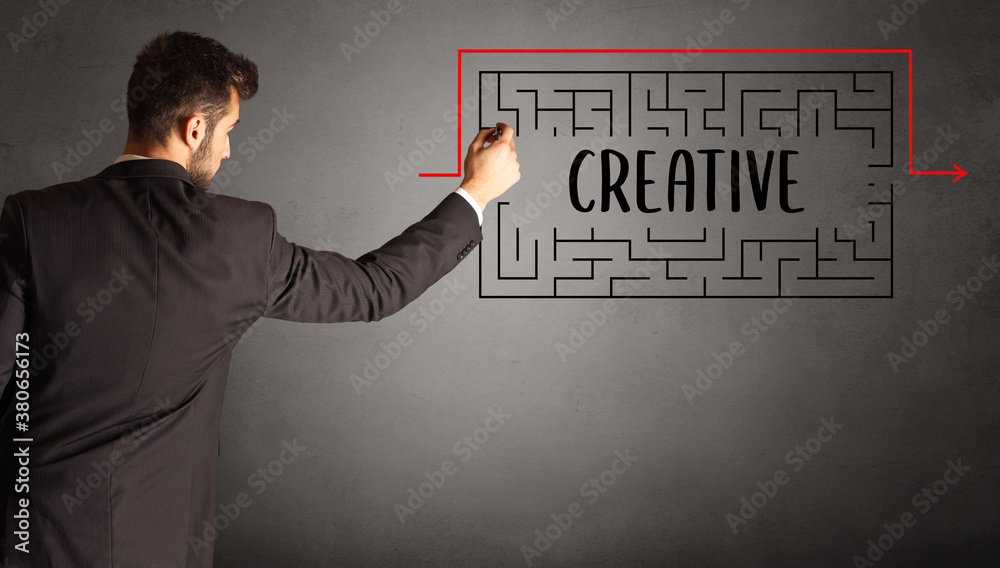 businessman drawing maze with CREATIVE inscription, business education concept businessman drawing maze with CREATIVE inscription, business education concept