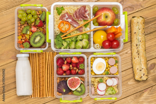 School lunch box with set of fruits, berries vegetables, ham.