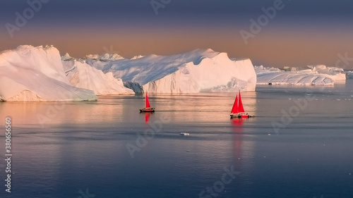 Greenland Ilulissat glaciers at ocean with red sailing boat