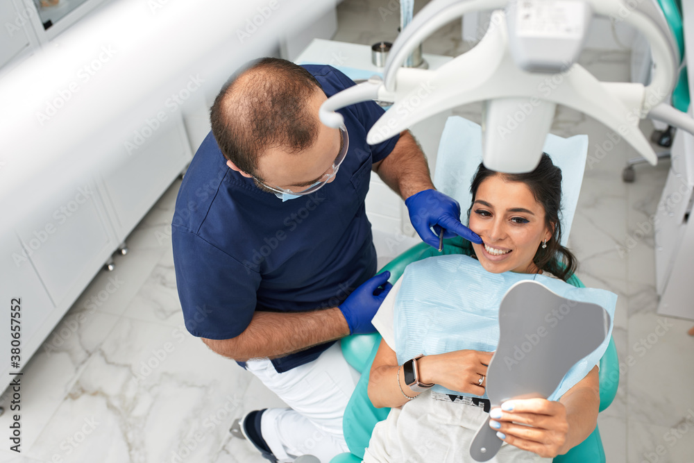 people, medicine, stomatology and health care concept - happy male dentist with woman patient at dental clinic office people, medicine, stomatology and health care concept - happy male dentist with woman patient at dental clinic office