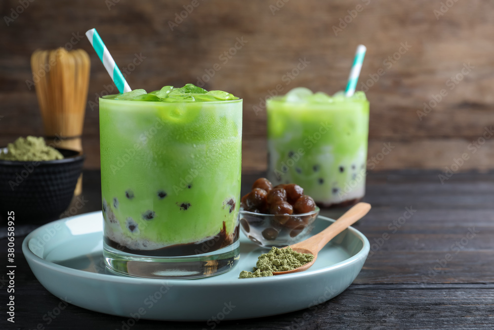 Tasty milk bubble tea with green matcha on black wooden table, closeup Tasty milk bubble tea with green matcha on black wooden table, closeup