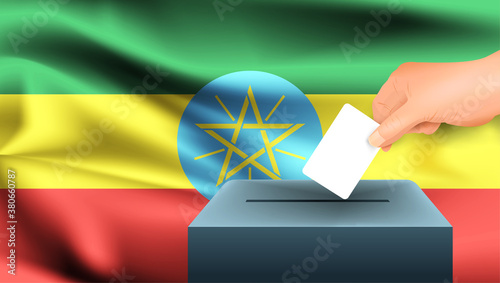 Male hand puts down a white sheet of paper with a mark as a symbol of a ballot paper against the background of the Ethiopia flag. Ethiopia the symbol of elections