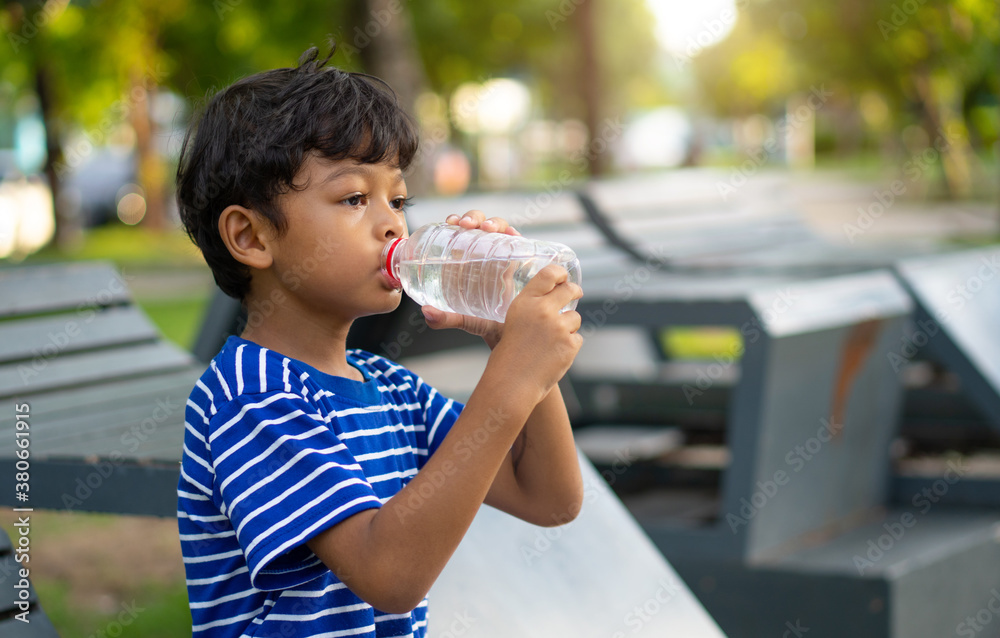 Kid drinking water from a transparent plastic bottle. Kid drinking water from a transparent plastic bottle.