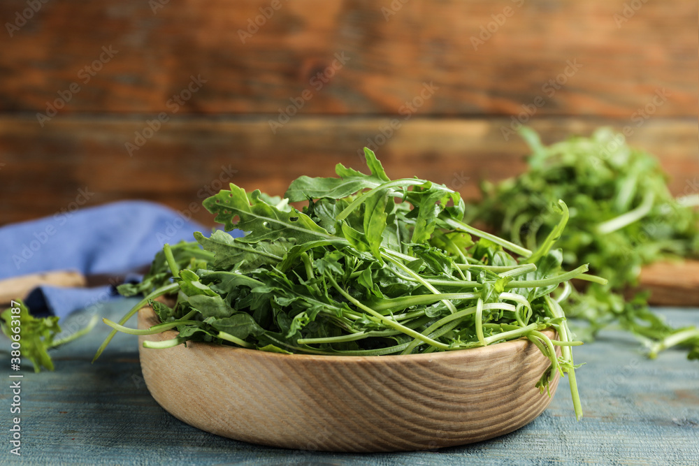 Fresh arugula leaves on blue wooden table Fresh arugula leaves on blue wooden table
