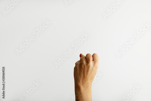 Female hand shows back side fist, on white background with free space for text