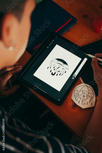 Professional tattoo artist doing a sketch on a graphic tablet.