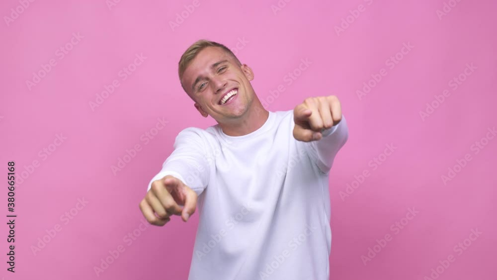 Young caucasian man cheerful smiles pointing to front Young caucasian man cheerful smiles pointing to front