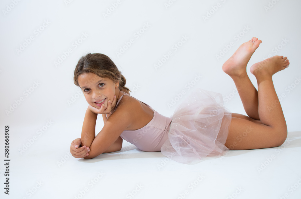 Beautiful little ballerina on floor doing stretching over white background Beautiful little ballerina on floor doing stretching over white background
