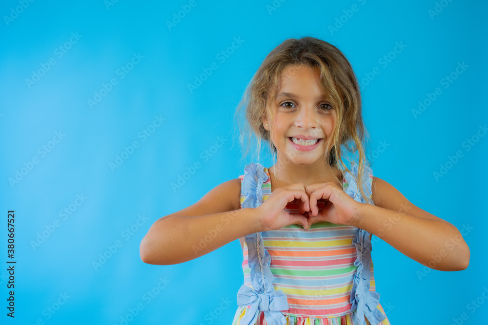 Little girl with swimsuit making heart figure