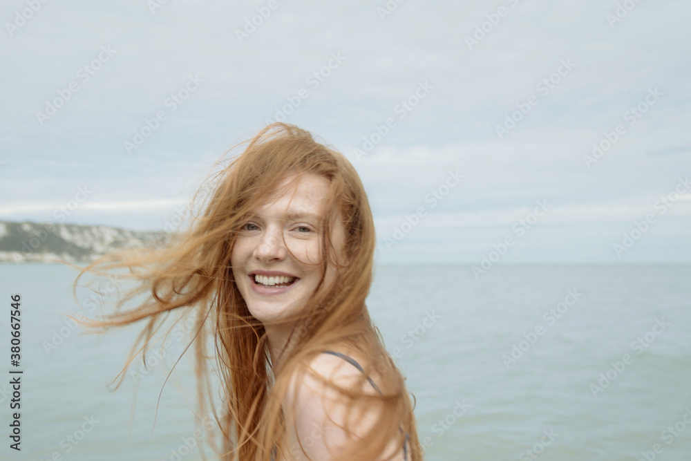 Young adult female in sea about to swim in winter Young adult female in sea about to swim in winter