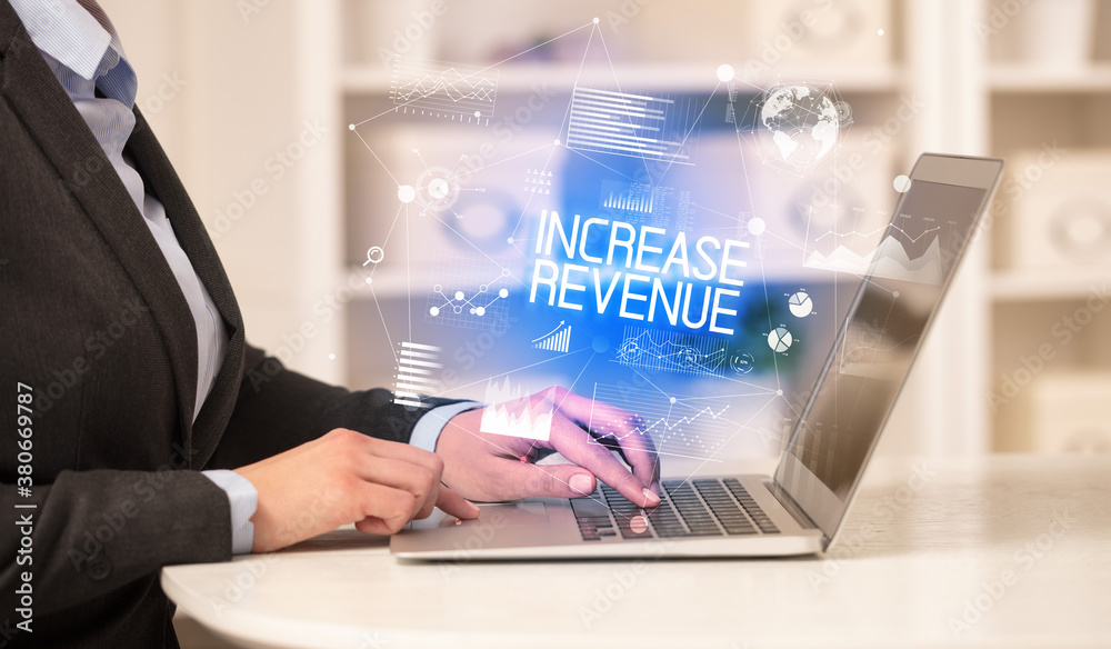 Side view of a business person working on laptop with INCREASE REVENUE inscription, modern business concept