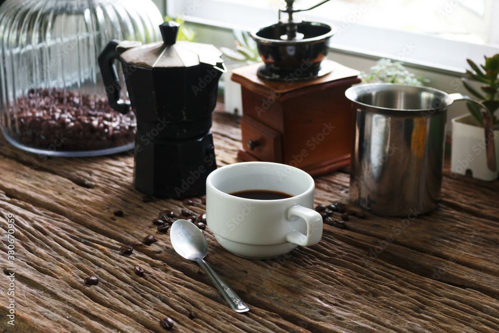 coffee mill with coffee cup on wooden table