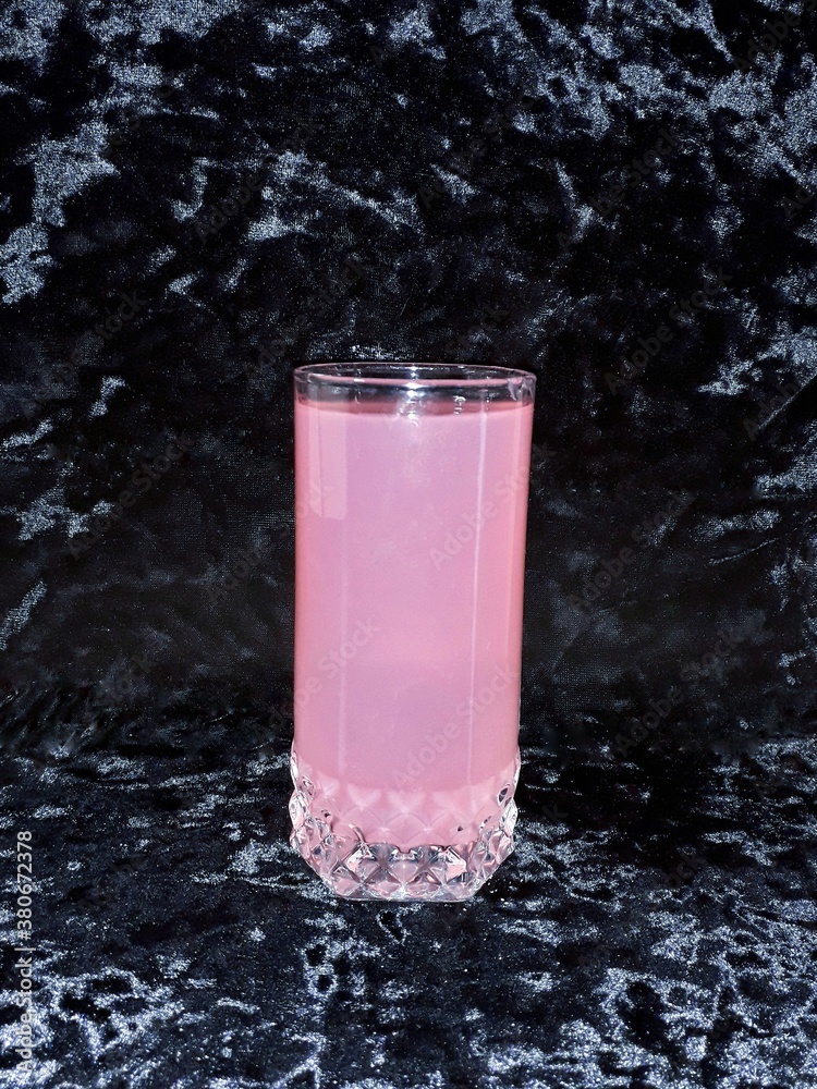 glass of juice on a black background glass of juice on a black background