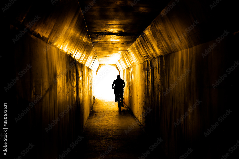 Man Biking Through Tunnel Towards the Light Man Biking Through Tunnel Towards the Light