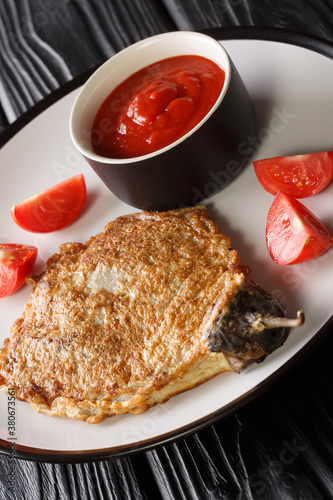 Filipino eggplant omelette Tortang Talong close-up in a plate on the table. Vertical photo