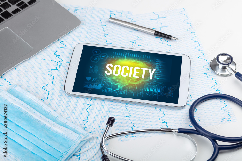 Tablet pc and medical tools with SOCIETY inscription, social distancing concept Tablet pc and medical tools with SOCIETY inscription, social distancing concept