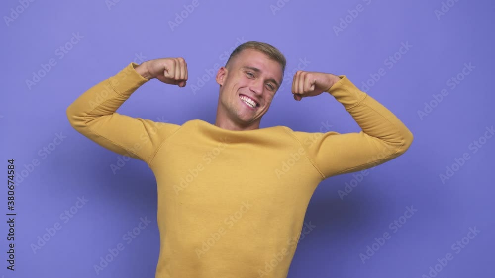 Young caucasian man showing strength gesture with arms, symbol of feminine power
