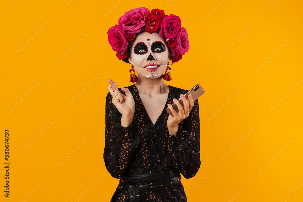 Photo of excited girl holding fingers together while using mobile phone Photo of excited girl holding fingers together while using mobile phone