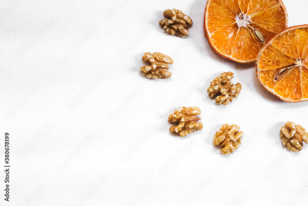 Dried oranges with nuts layout. Autumn / winter theme background. Corner border from top view, empty space for text.