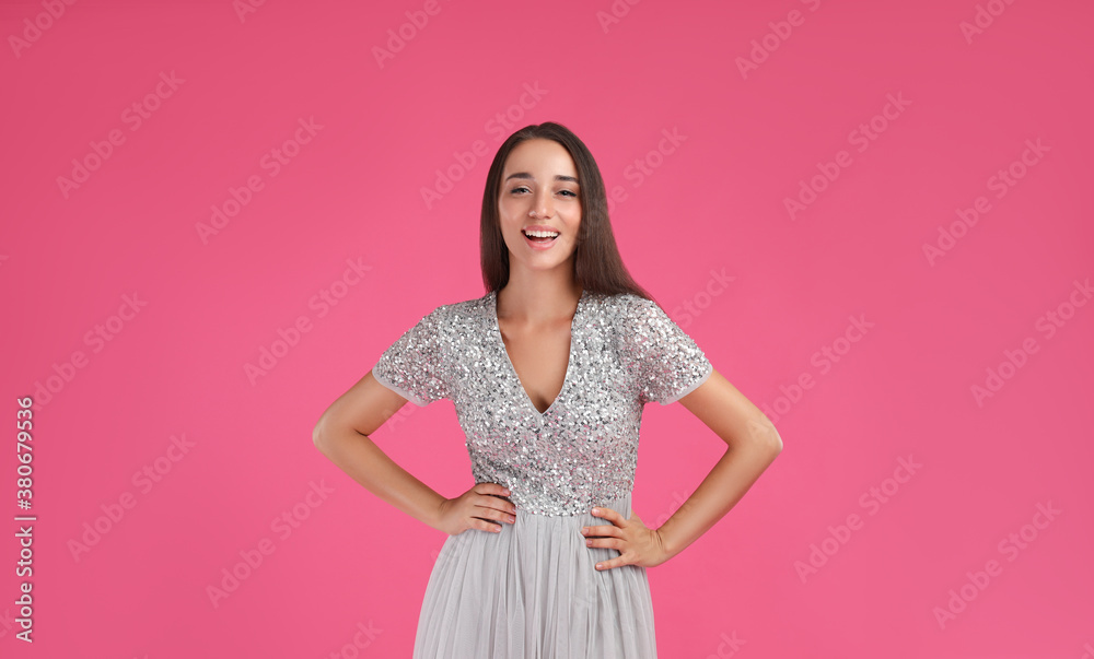 Young woman wearing stylish dress on pink background