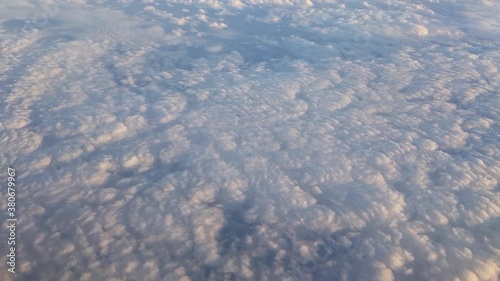 Flying over fluffy clouds with the sun reflecting. photo