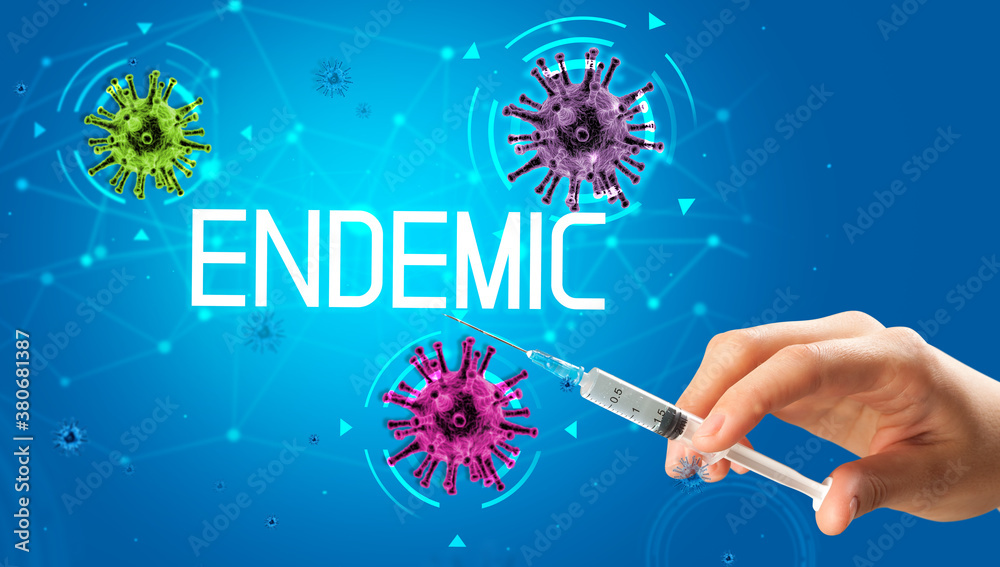 Syringe, medical injection in hand with ENDEMIC inscription, coronavirus vaccine concept Syringe, medical injection in hand with ENDEMIC inscription, coronavirus vaccine concept