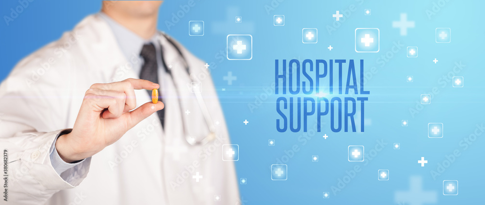 Close-up of a doctor giving a pill with HOSPITAL SUPPORT inscription, medical concept Close-up of a doctor giving a pill with HOSPITAL SUPPORT inscription, medical concept
