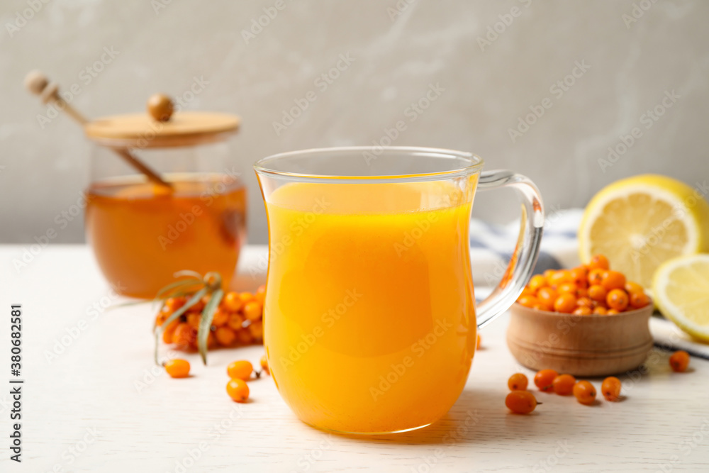 Fresh sea buckthorn tea on white wooden table, closeup Fresh sea buckthorn tea on white wooden table, closeup