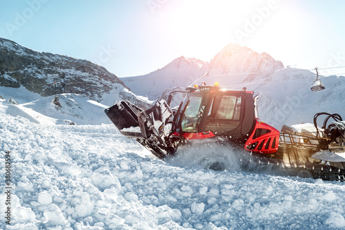 Photos Red modern snowcat ratrack with snowplow snow grooming machine preparing ski slope piste hill at alpine skiing winter resort Ischgl in Austria