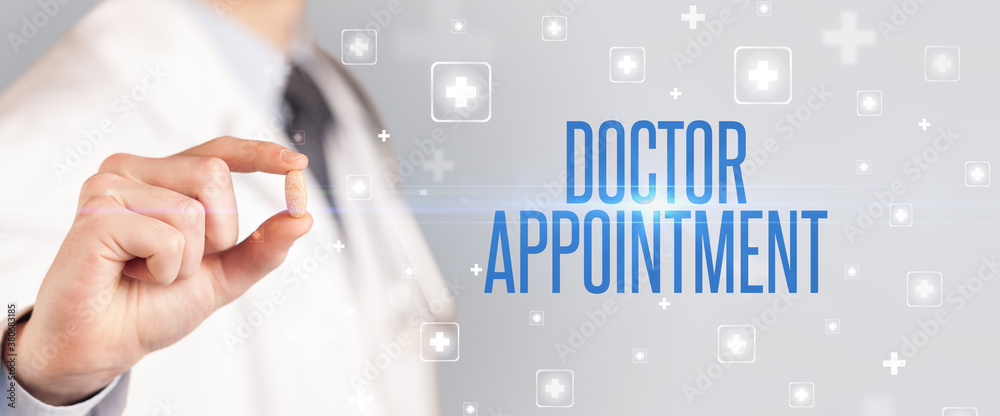 Close-up of a doctor giving a pill with DOCTOR APPOINTMENT inscription, medical concept Close-up of a doctor giving a pill with DOCTOR APPOINTMENT inscription, medical concept