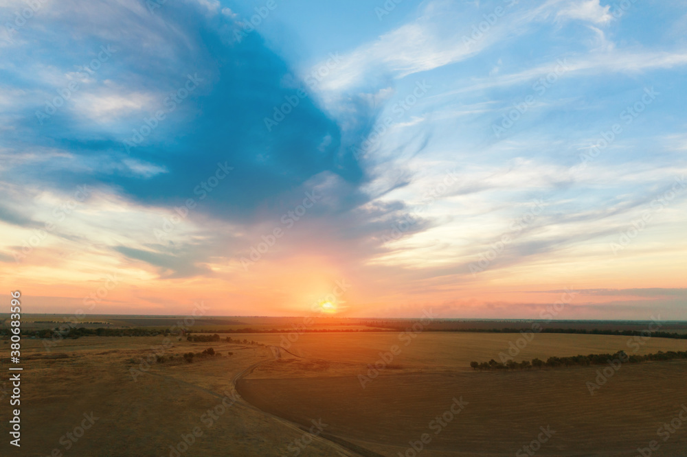 Amazing cloudy sky over fields, aerial view. Sunset landscape