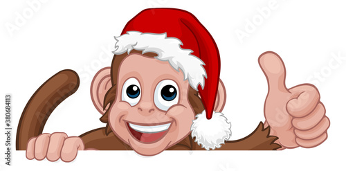 A Christmas monkey animal cartoon character in a Santa hat behind a sign peeking over a sign and giving a thumbs up