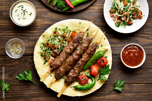 Turkish Adana Kebab with fresh vegetables on flatbread