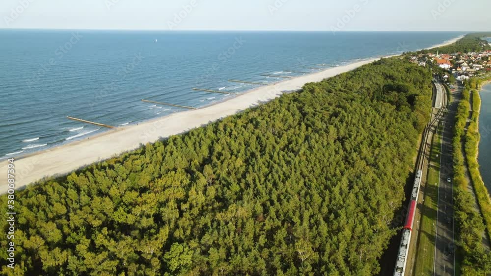 Aerial Cinematic view on road between green forest Baltic Sea and guld of Gdansk, Kuznica Poland