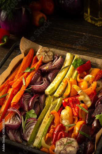 Stewed vegetables on a baking sheet, carrots with garlic and red onions,zucchini with bell pepper and beetroot, sweet and hot peppers and spices