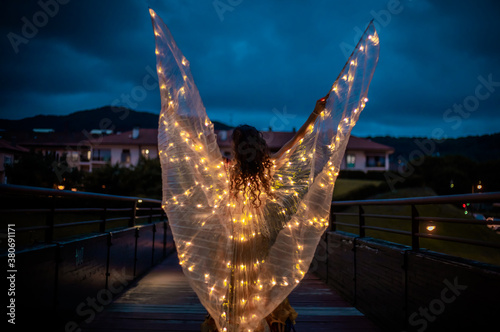 Belly dancer with light wings at night