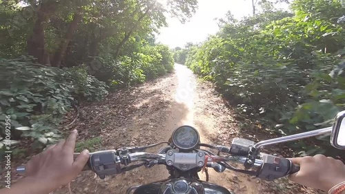 Biker riding offroad in a dense green alley riding to the mountain at Parasnath Hill in Jharkhand, India. photo