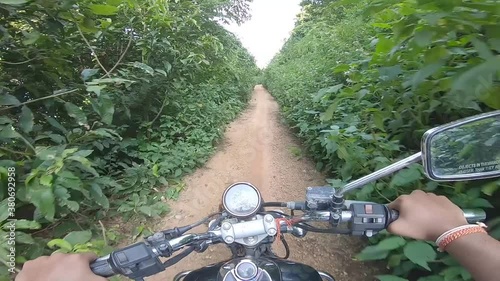 Biker riding offroad in a dense green alley riding to the mountain at Parasnath Hill in Jharkhand, India. photo