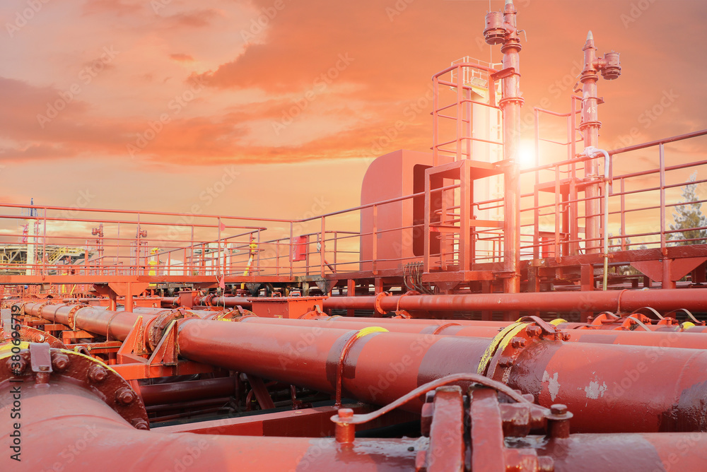 Many Pipes on Red Tanker with sunset background.