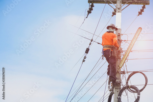 Double exposure Electrician climbing poles workers on height wearing safety belt on sunset background.