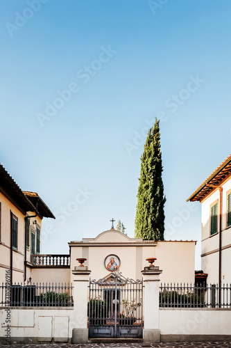 Tiny sanctum on the streets in Bagno a Ripoli in Tuscany and iconic cypress tree.