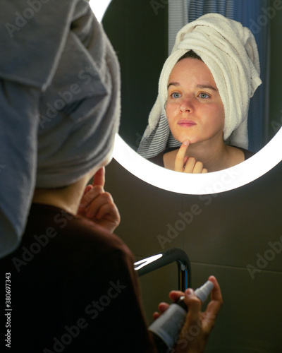 Young woman checking her skin. Skin care concept.