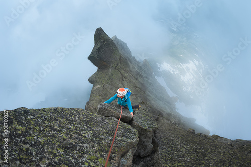 Climber climbing above the clouds photo