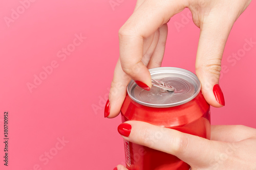 Woman with red nail varnish opens pop can photo