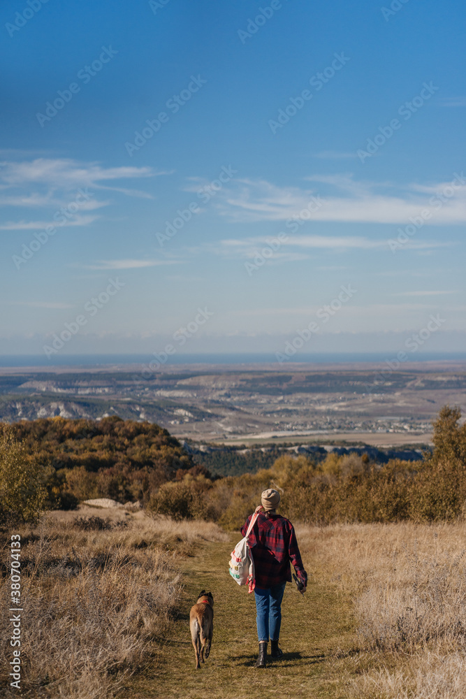 Hipster girl and her dog are walking on the road. Hipster girl and her dog are walking on the road.