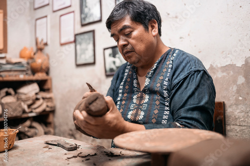 Vászonkép Mexican artisan sculpting with mud