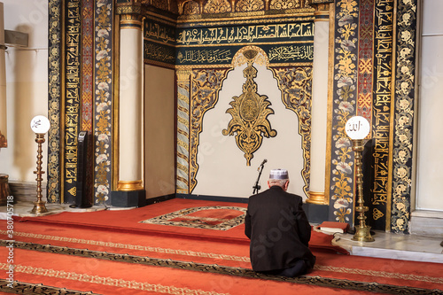 Bursa/Turkey - November 8, 2019:  Muslim man praying near the mihrab in Ulu Cami (Grand Mosque) indoor. Ulucami is landmark from Ottoman Empire and the largest mosque in Bursa. photo