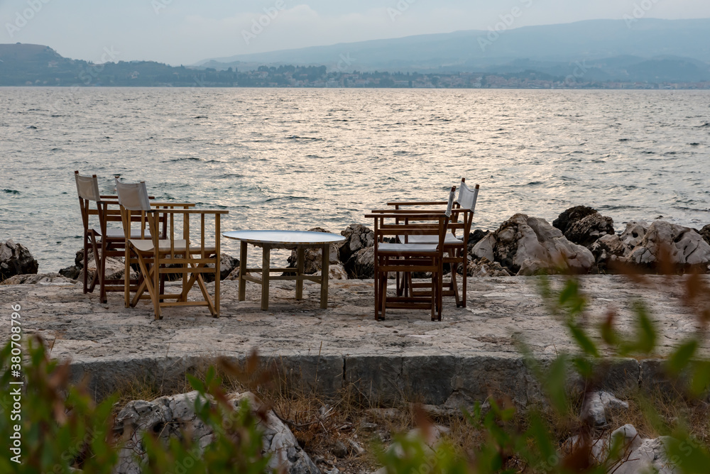 Small tables of a restaurant by the Greek sea Small tables of a restaurant by the Greek sea