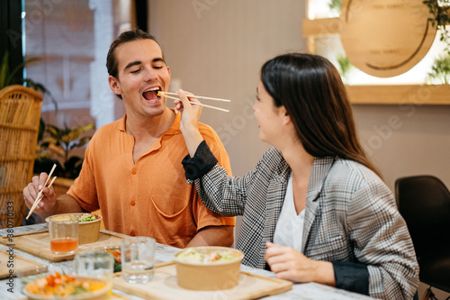 Couple eating poke bowl with chopsticks photo